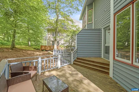 a view of a patio with table and chairs with wooden floor and fence