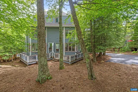 a view of a house with backyard and a tree