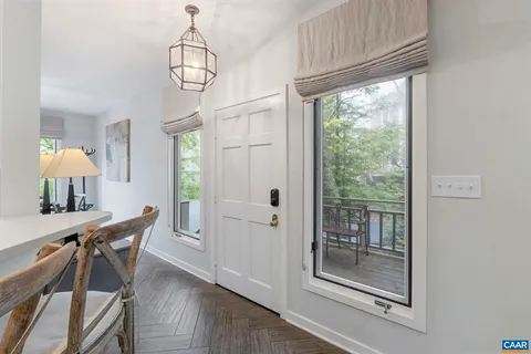a view of a hallway with furniture and chandelier