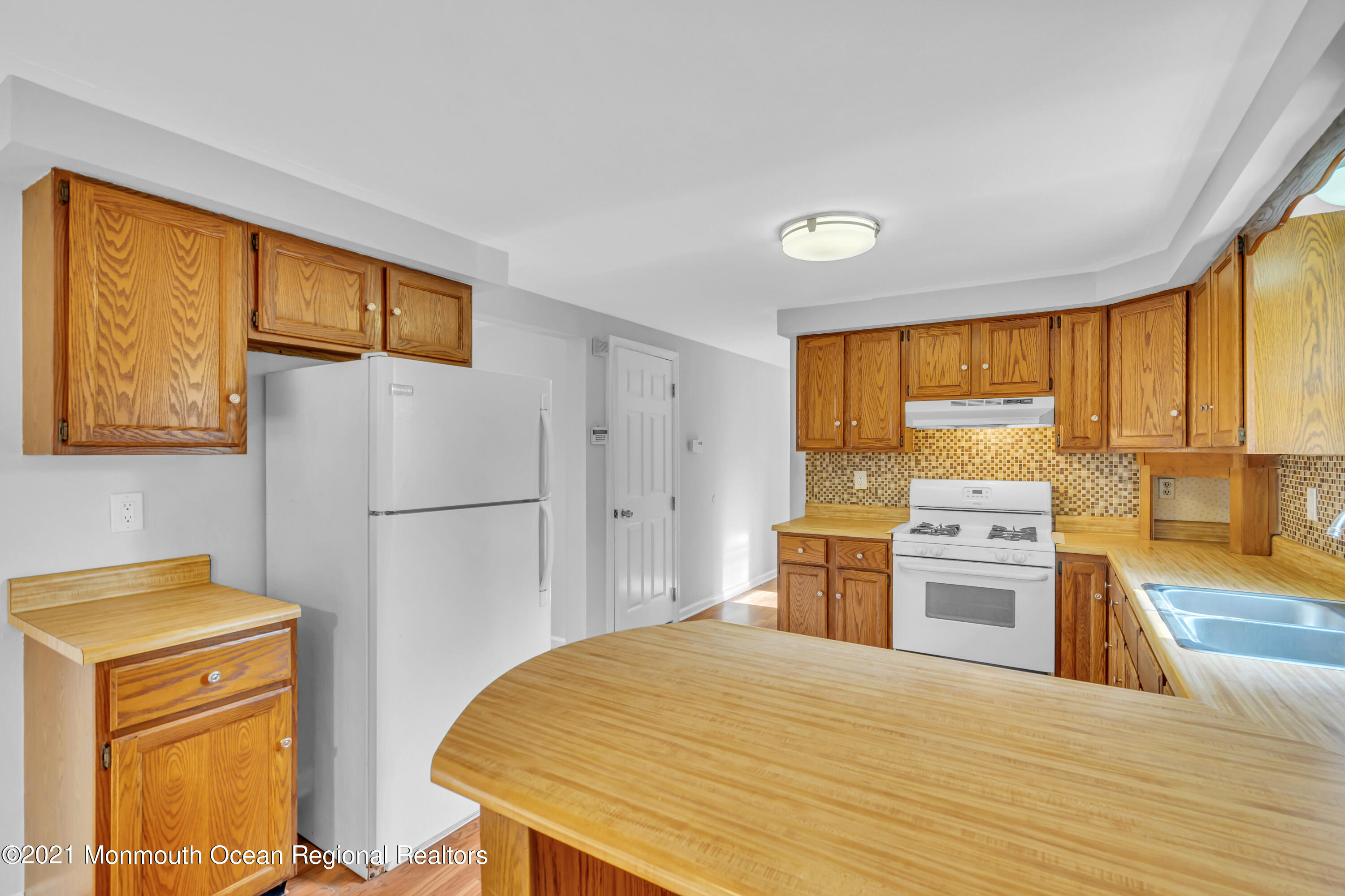 11 Tennent Road Morganville, NJ 07751 - Photo 8 of 20 a kitchen with a stove a refrigerator and a sink