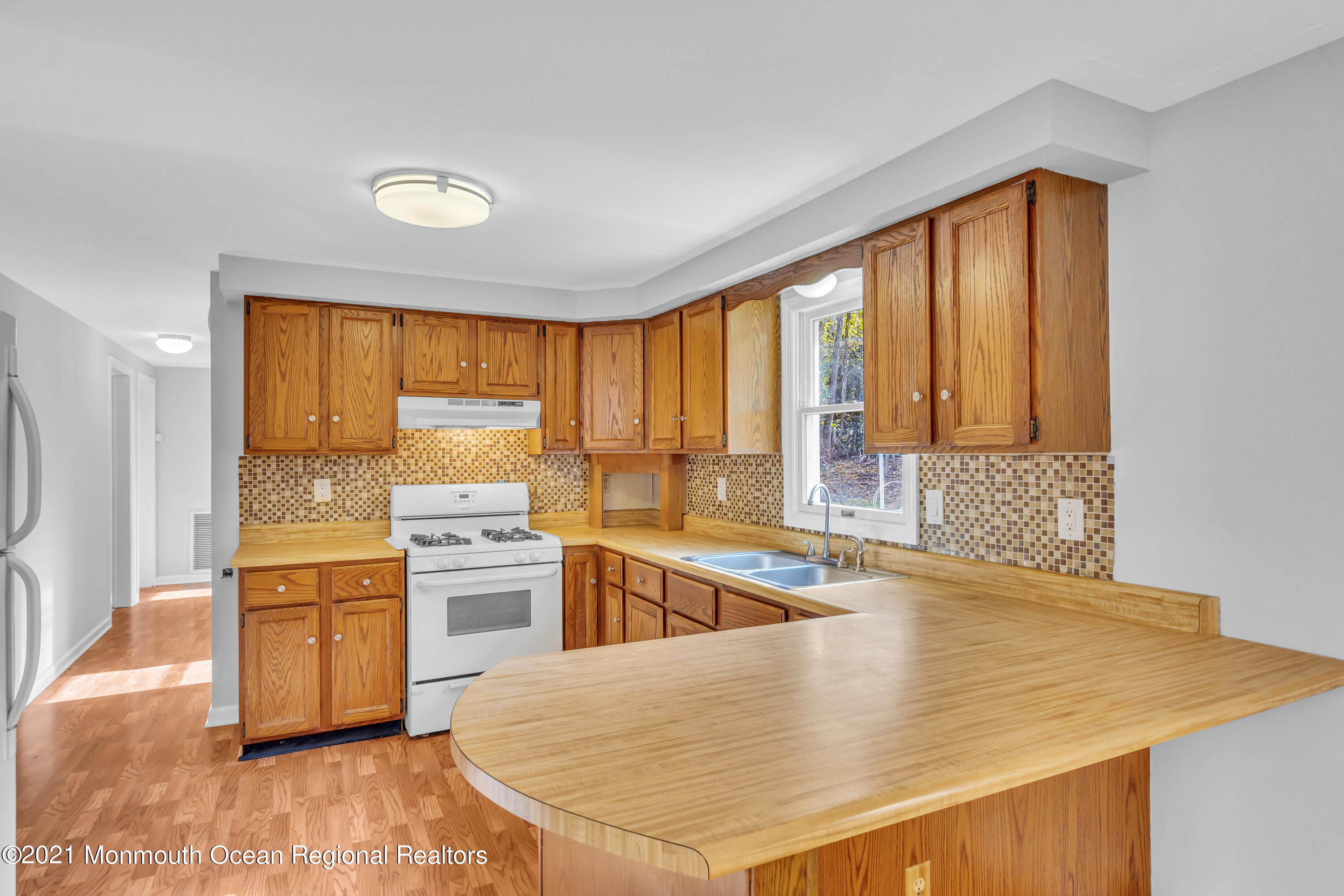 11 Tennent Road Morganville, NJ 07751 - Photo 9 of 20 a kitchen with a stove a refrigerator and cabinets