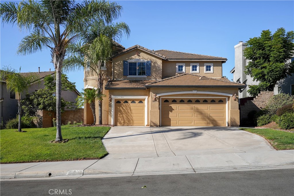 a front view of a house with a garden and trees