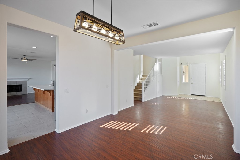 38815 Cobblestone Circle Murrieta, CA 92563 - Photo 12 of 49 a view of an empty room with wooden floor and a ceiling fan