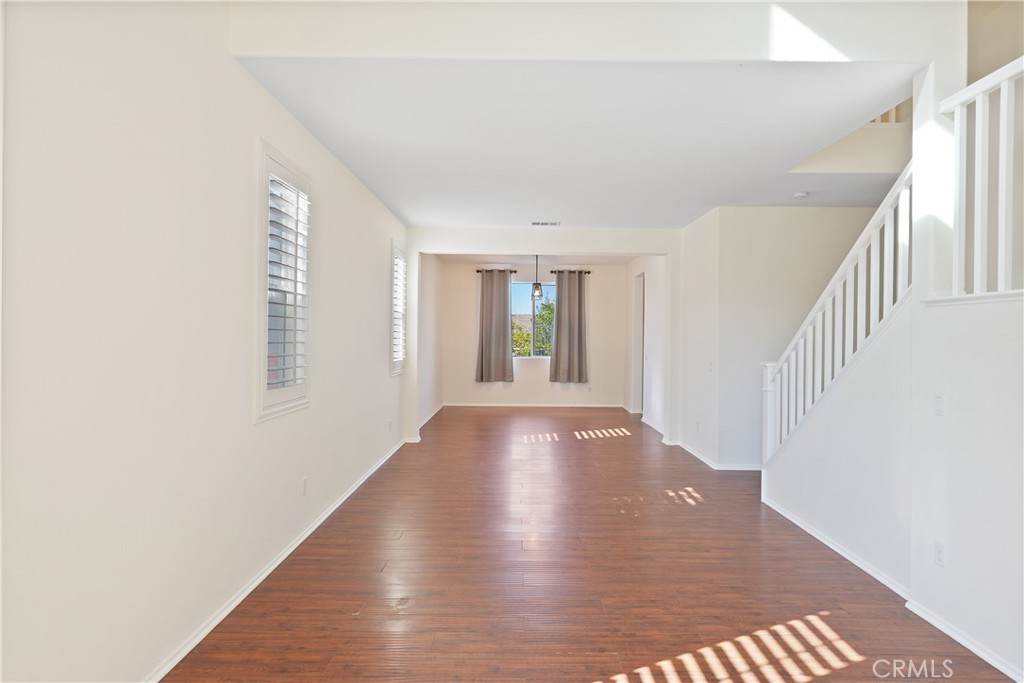 38815 Cobblestone Circle Murrieta, CA 92563 - Photo 13 of 49 a view of an empty room with wooden floor and a window
