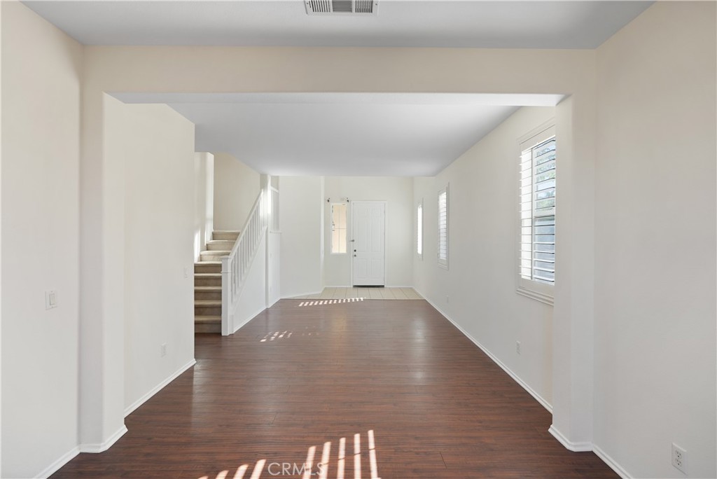 38815 Cobblestone Circle Murrieta, CA 92563 - Photo 17 of 49 a view of an empty room with wooden floor and a window