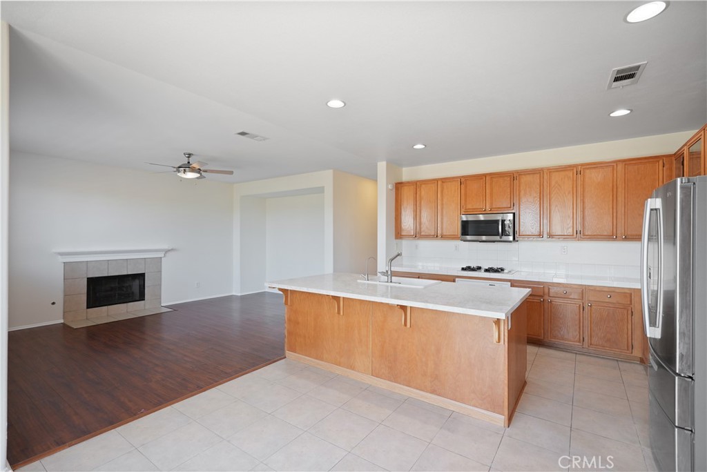 38815 Cobblestone Circle Murrieta, CA 92563 - Photo 6 of 49 a large kitchen with stainless steel appliances granite countertop a refrigerator a stove and a sink with wooden floor
