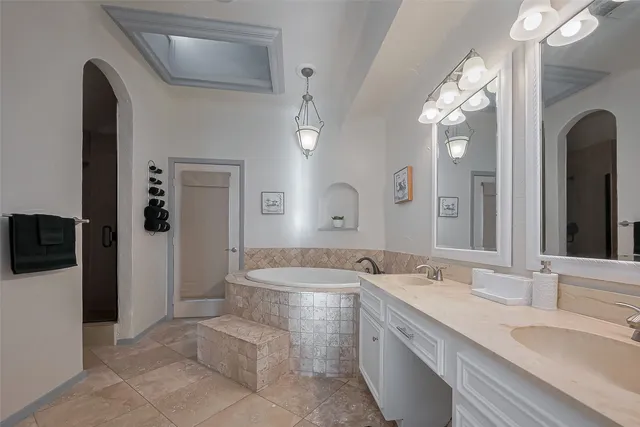 a spacious bathroom with a granite countertop sink a toilet a mirror and bathtub
