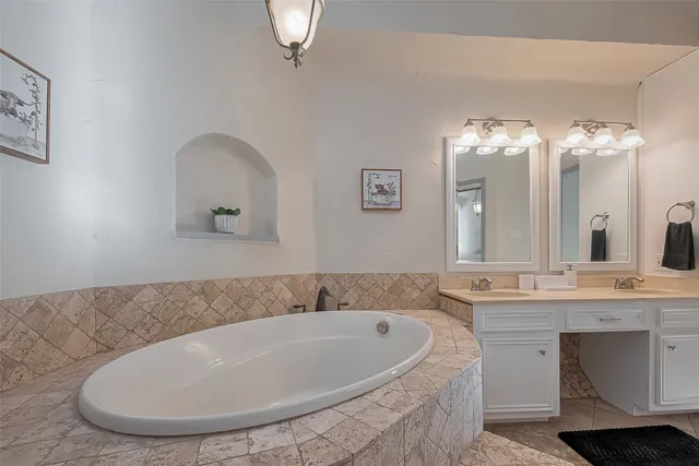 a bathroom with a tub sink and mirror