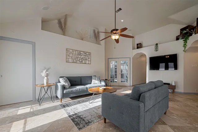 a living room with furniture a chandelier and a window