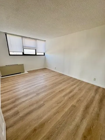 a view of a room with wooden floor and a window