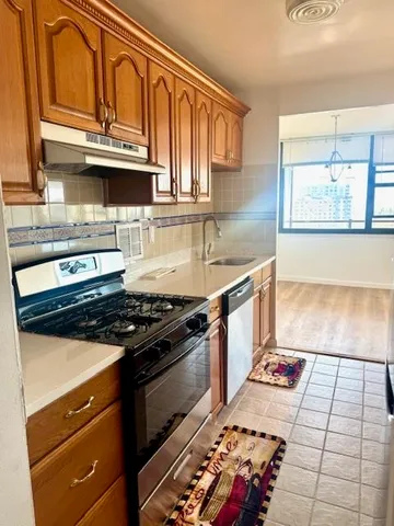 a kitchen with granite countertop a stove and a sink