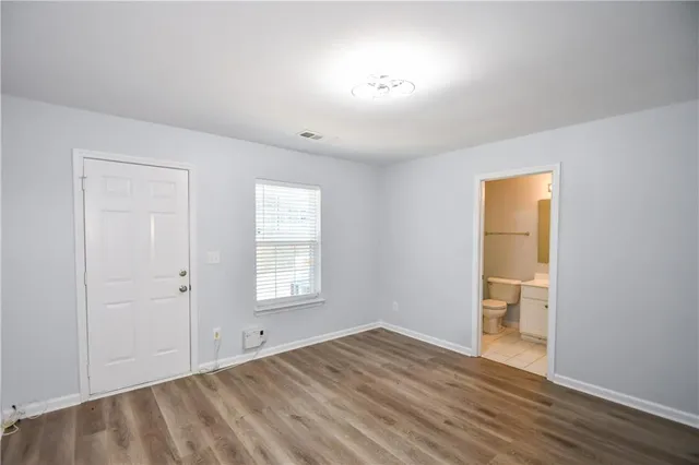 an empty room with a window and wooden floor
