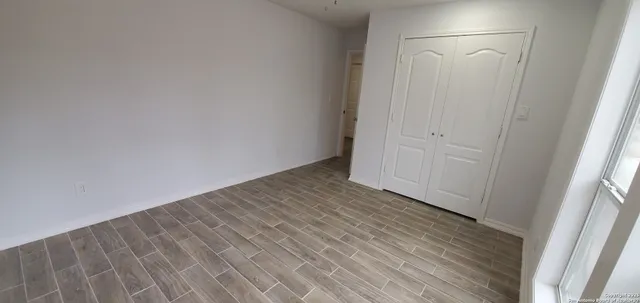 a view of an empty room with cabinet and a window