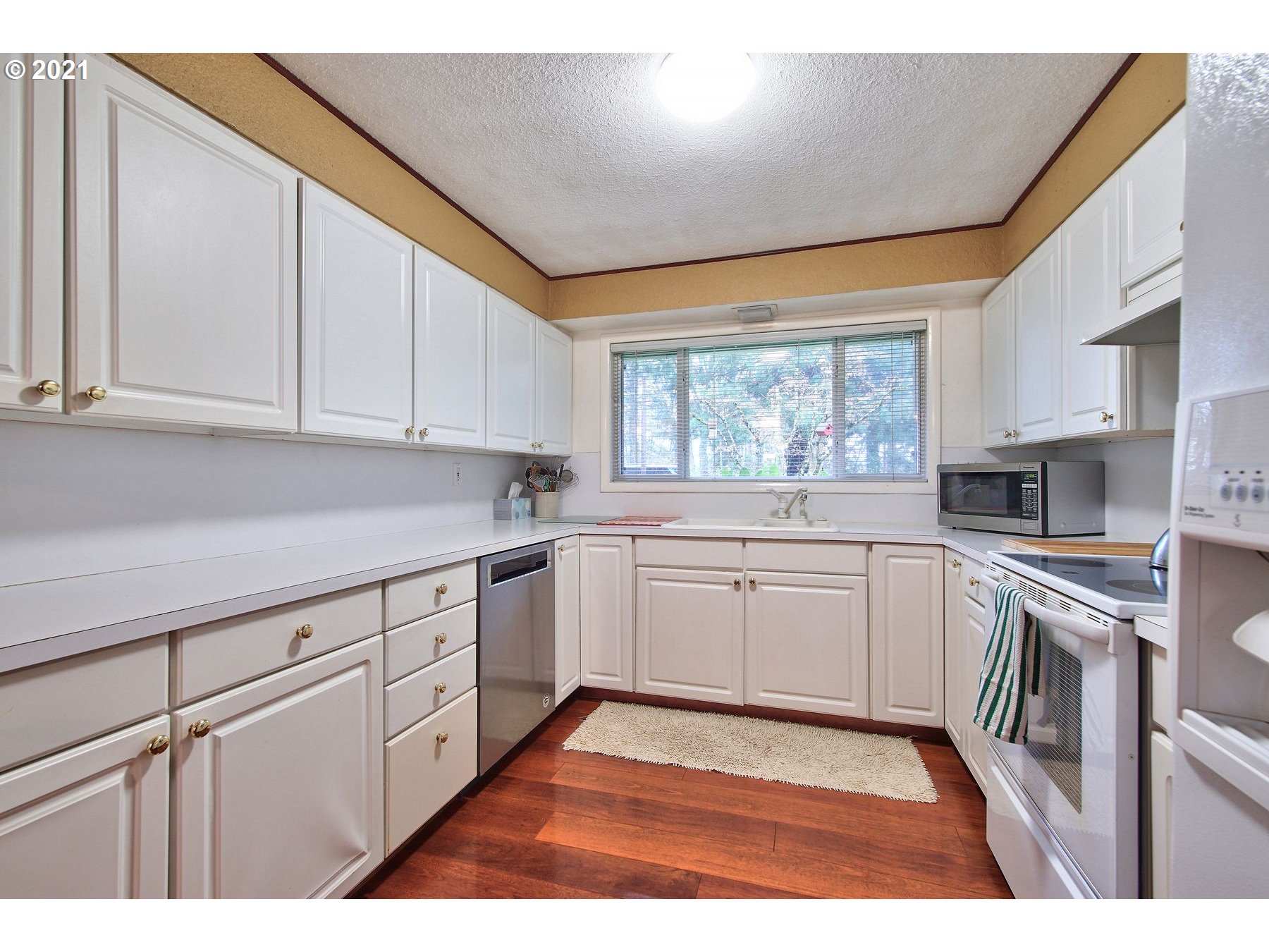 29223 South Meridian Road Hubbard, OR 97032 - Photo 11 of 32 a kitchen with granite countertop white cabinets and white appliances