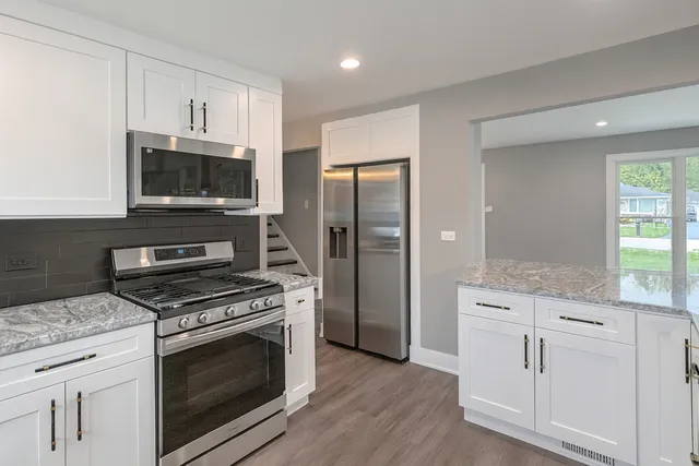 a kitchen with white cabinets and stainless steel appliances