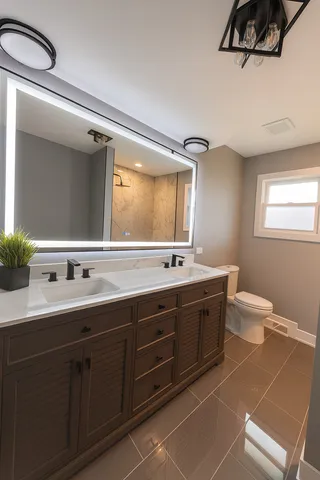 a bathroom with a double vanity sink mirror and toilet
