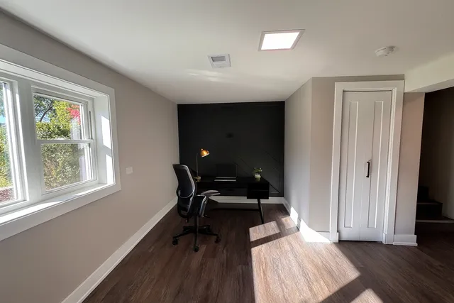 a view of a workspace with furniture and a window