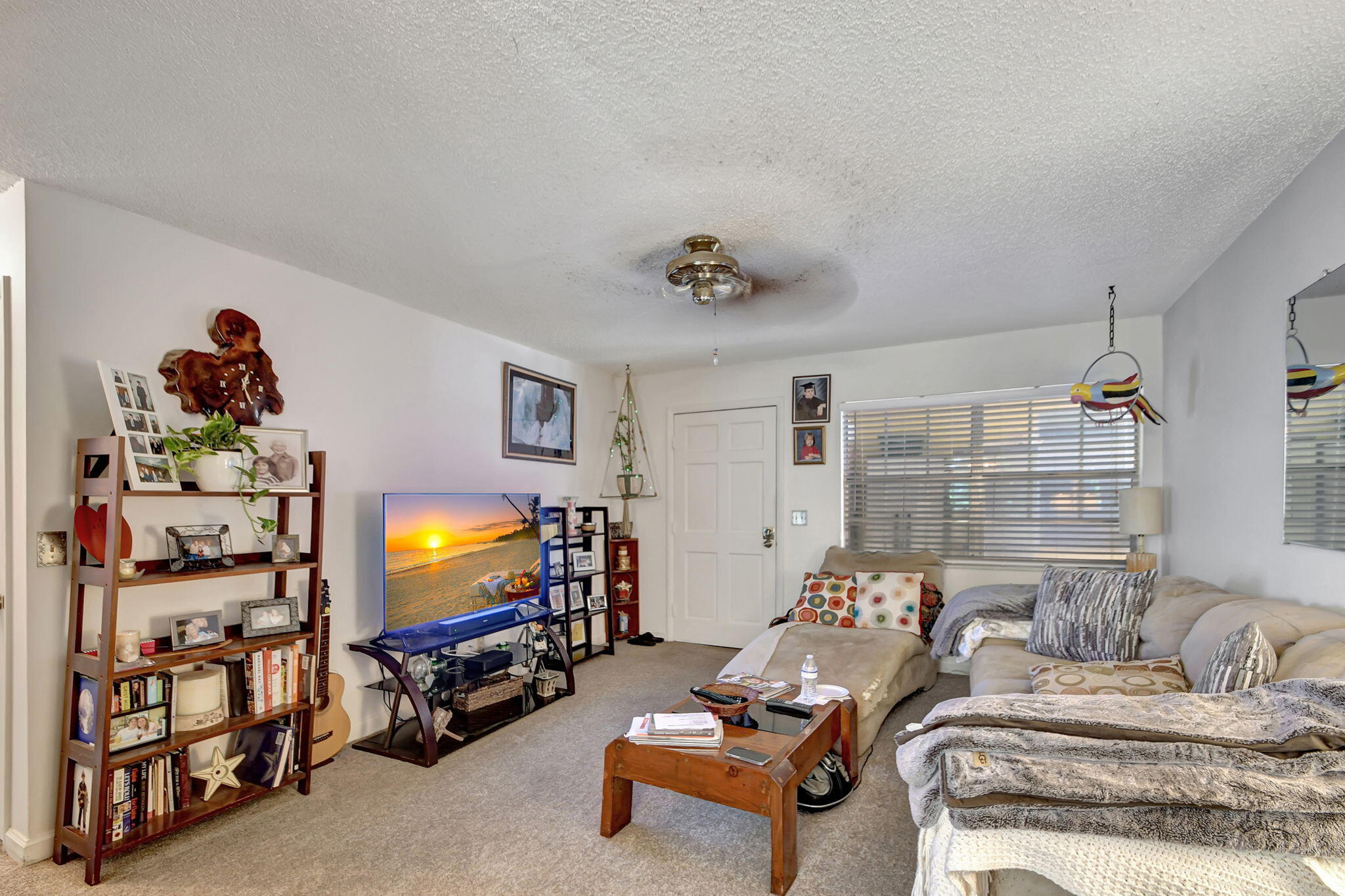 1853 Service Road North Palm Beach, FL 33408 - Photo 41 of 113 a living room with furniture a flat screen tv and a floor to ceiling window