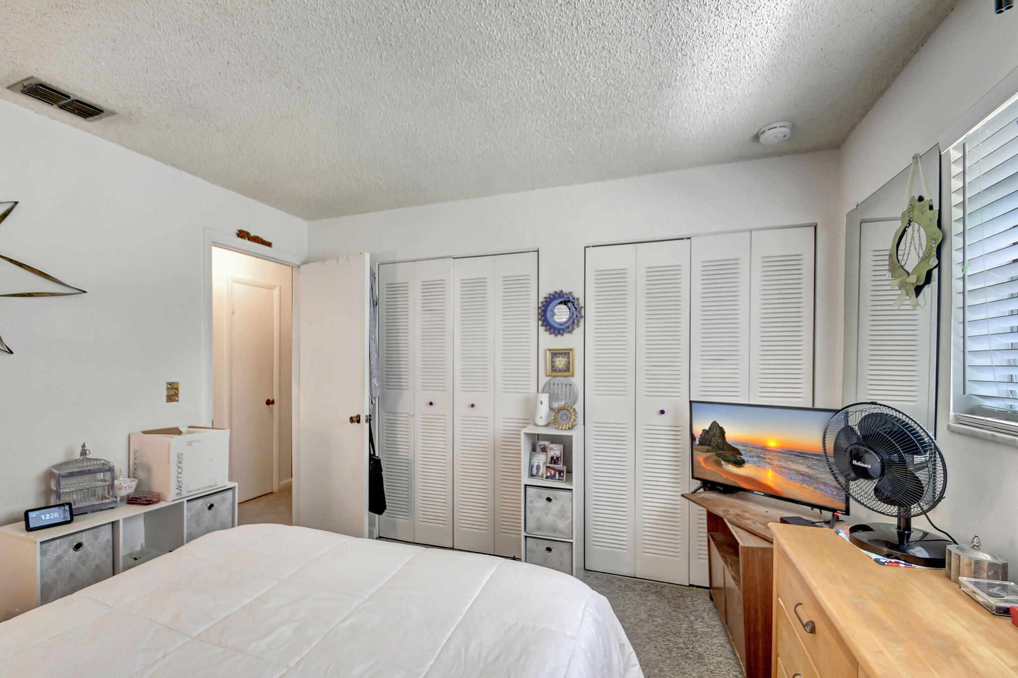 1853 Service Road North Palm Beach, FL 33408 - Photo 49 of 113 a bedroom with a bed and a dresser next to a window