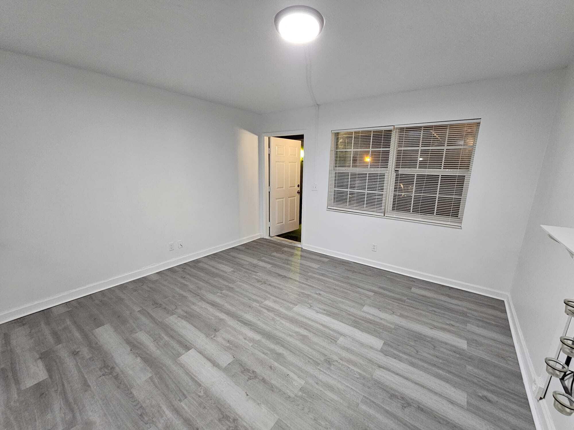 1853 Service Road North Palm Beach, FL 33408 - Photo 64 of 113 an empty room with wooden floor and windows