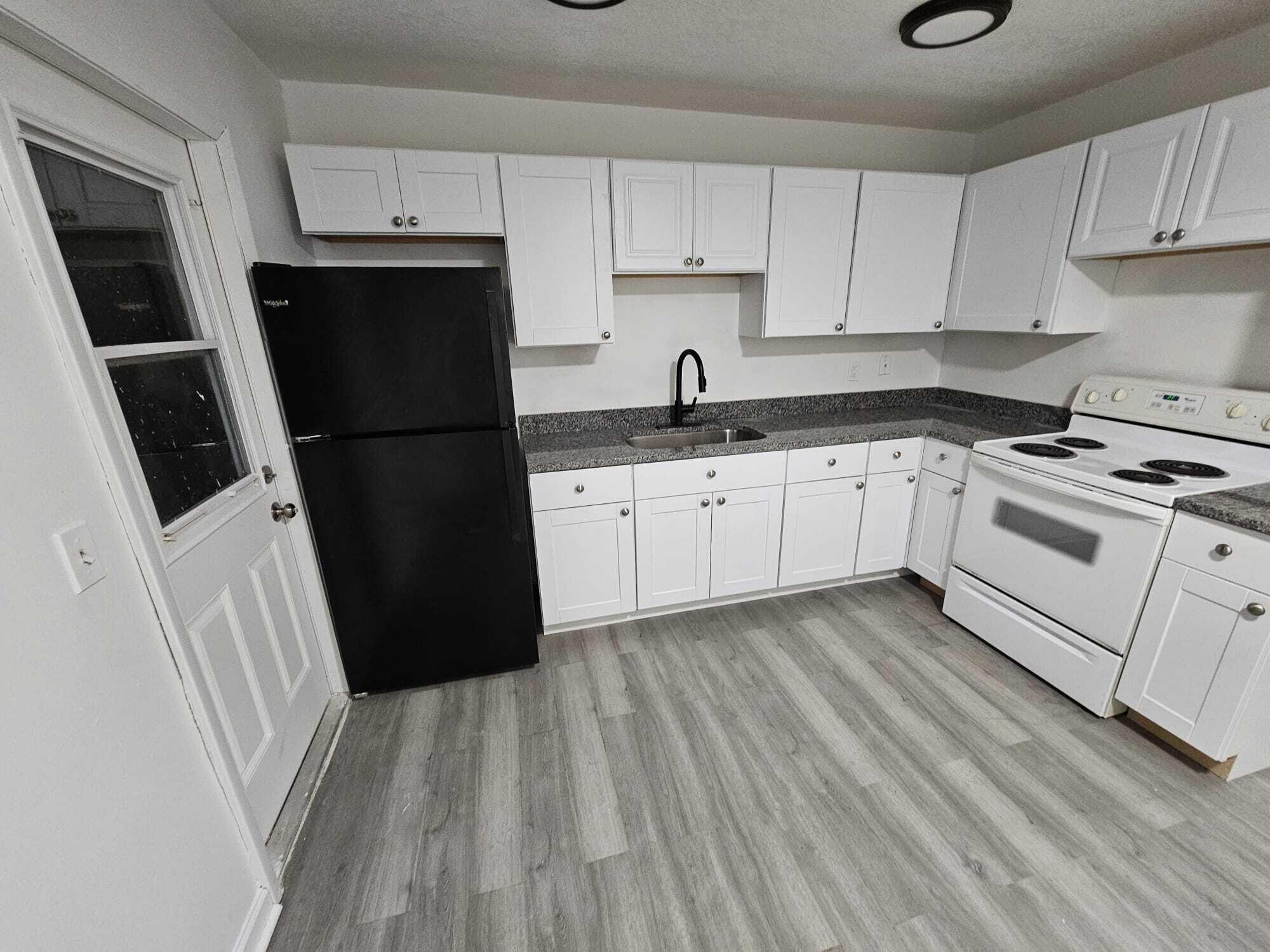 1853 Service Road North Palm Beach, FL 33408 - Photo 67 of 113 a kitchen with a sink a refrigerator a microwave and cabinets