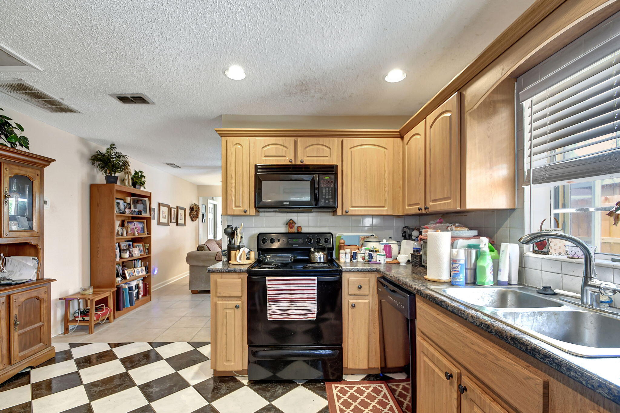 1853 Service Road North Palm Beach, FL 33408 - Photo 81 of 113 a kitchen with stainless steel appliances granite countertop a stove top oven a sink a dining table and chairs with wooden floor