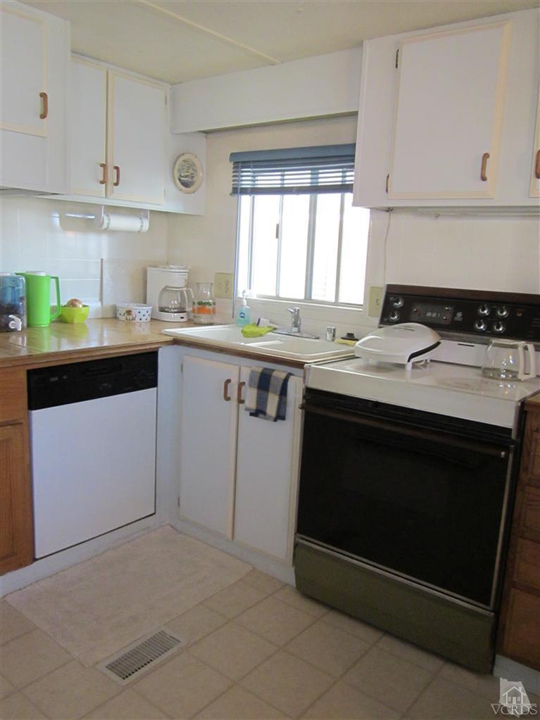 1225 South Rice Road, Unit 72 Ojai, CA 93023 - Photo 3 of 9 a kitchen with stainless steel appliances granite countertop a stove a sink and a microwave