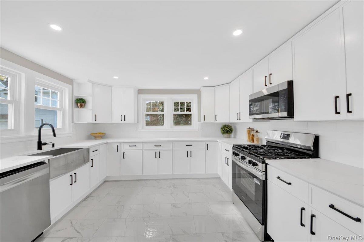 34 Kings Ferry Road Montrose, NY 10548 - Photo 12 of 36 Kitchen featuring appliances with stainless steel finishes, light marble finish flooring, white cabinetry, recessed lighting, and open shelves