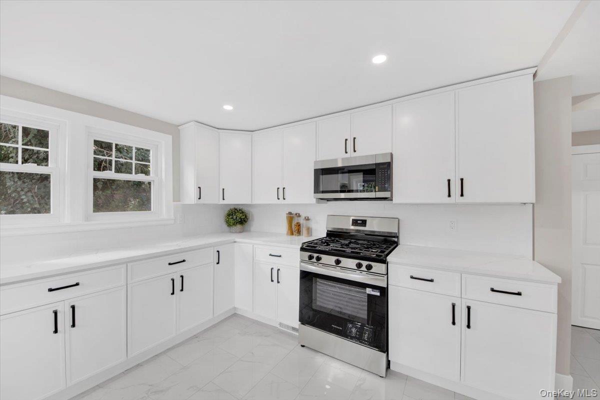 34 Kings Ferry Road Montrose, NY 10548 - Photo 14 of 36 Kitchen featuring stainless steel appliances, white cabinets, light marble finish flooring, recessed lighting, and light stone counters