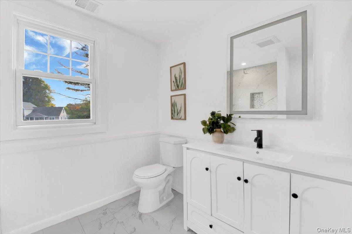 34 Kings Ferry Road Montrose, NY 10548 - Photo 22 of 36 Bathroom featuring a wainscoted wall, vanity, light marble finish flooring, and a marble finish shower