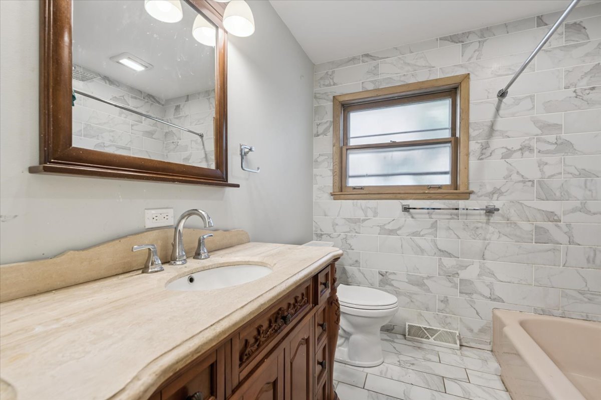 1009 South Washington Avenue Park Ridge, IL 60068 - Photo 14 of 24 a bathroom with a sink a toilet and a mirror