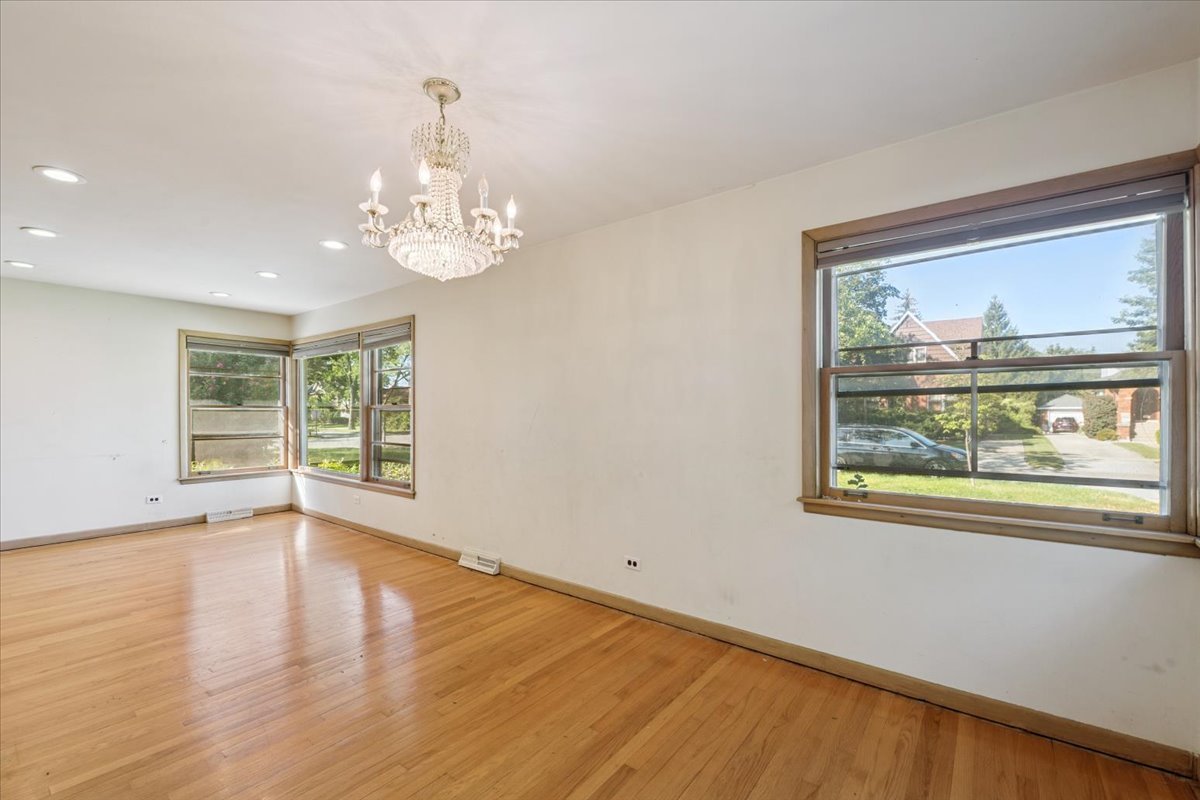 1009 South Washington Avenue Park Ridge, IL 60068 - Photo 4 of 24 a view of an empty room with wooden floor and a window