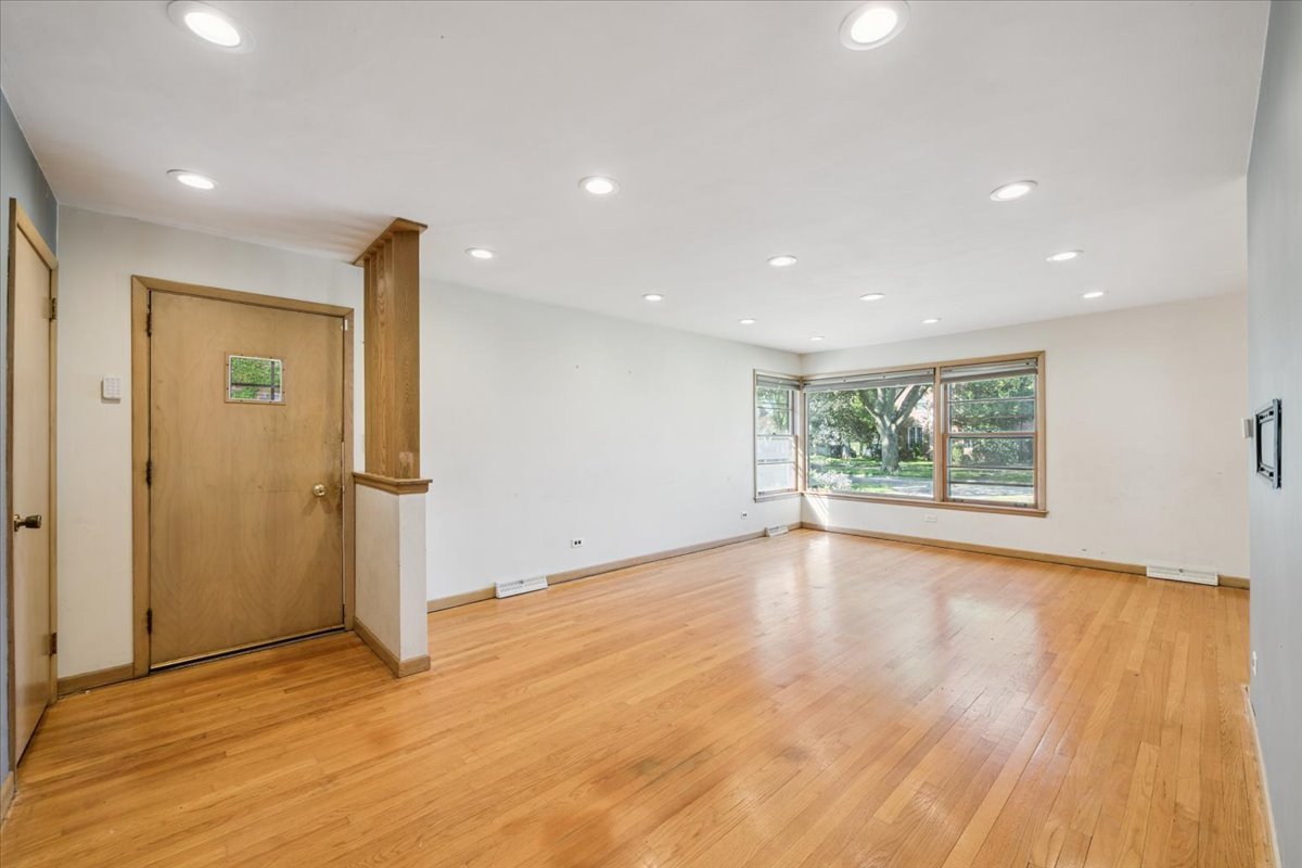 1009 South Washington Avenue Park Ridge, IL 60068 - Photo 5 of 24 a view of an empty room with wooden floor and a window