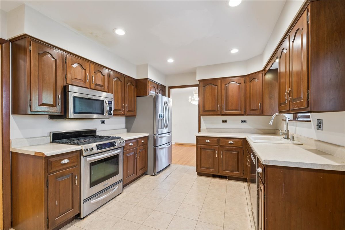 1009 South Washington Avenue Park Ridge, IL 60068 - Photo 6 of 24 a kitchen with stainless steel appliances granite countertop wooden cabinets a sink dishwasher a stove and a refrigerator