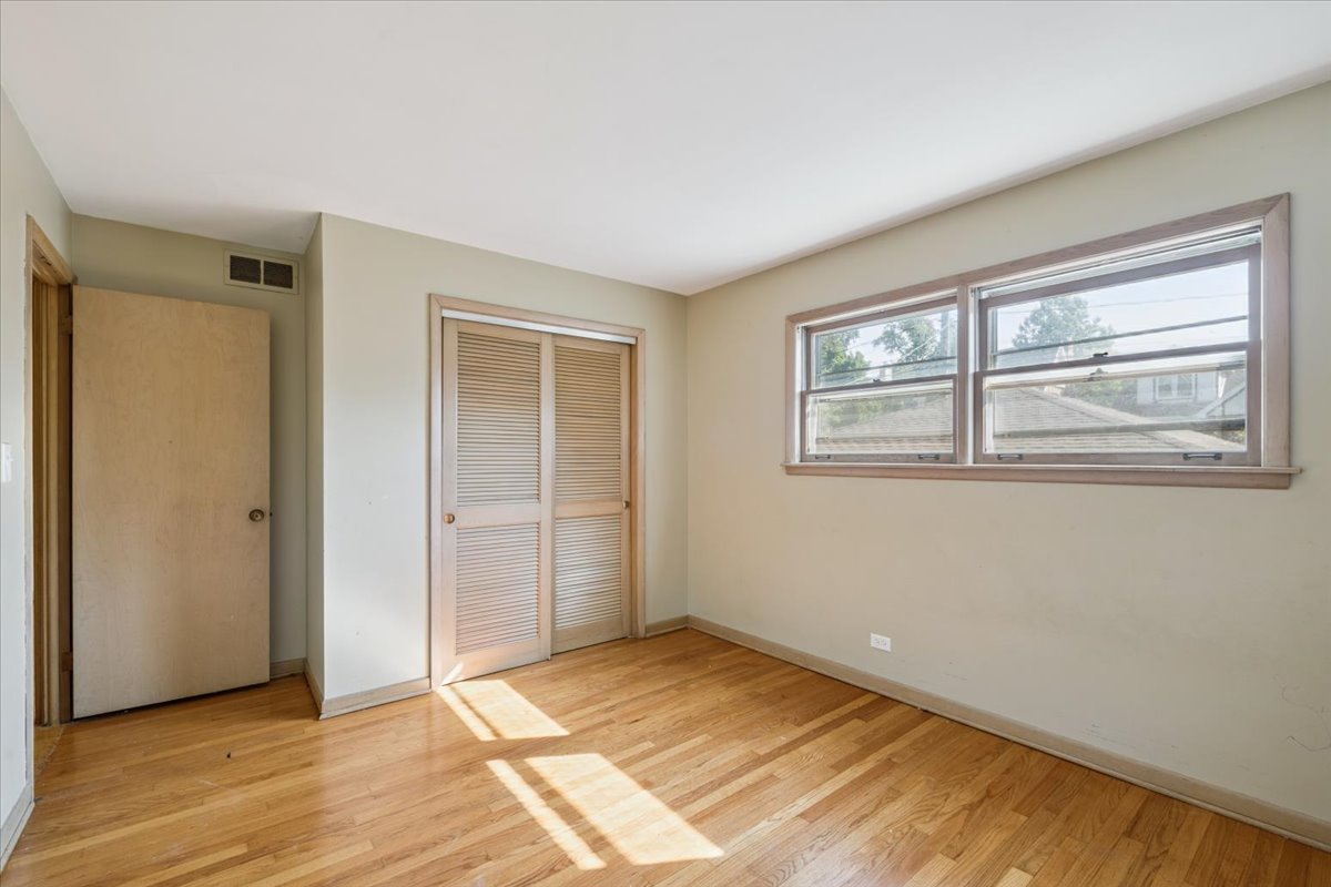 1009 South Washington Avenue Park Ridge, IL 60068 - Photo 10 of 24 a view of an empty room with wooden floor and a window