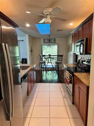 a kitchen with stainless steel appliances granite countertop a refrigerator and a stove top oven