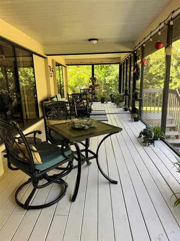 a living room with large windows table and chairs
