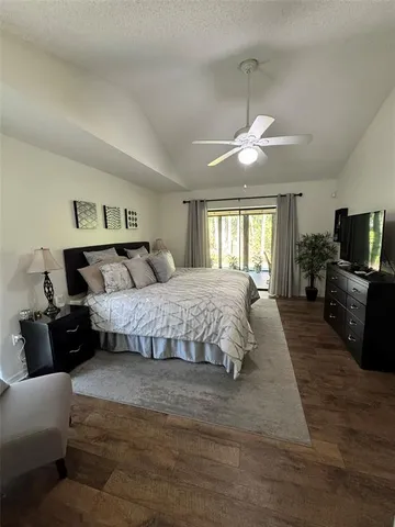 a bedroom with a large bed a flat tv screen and a dresser
