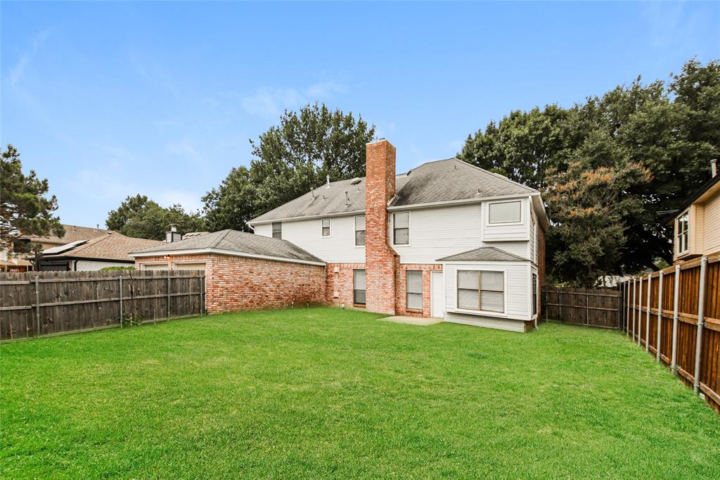 813 Ridgemont Drive Allen, TX 75002 - Photo 25 of 27 Rear view of house with a chimney, a fenced backyard, and brick siding