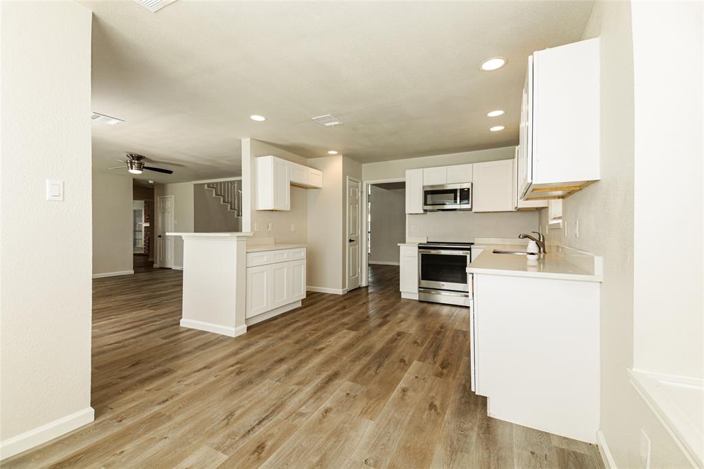 813 Ridgemont Drive Allen, TX 75002 - Photo 10 of 27 Kitchen with stainless steel appliances, recessed lighting, white cabinetry, and light wood-style floors