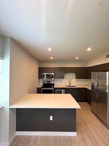 a kitchen with stainless steel appliances a refrigerator sink and microwave