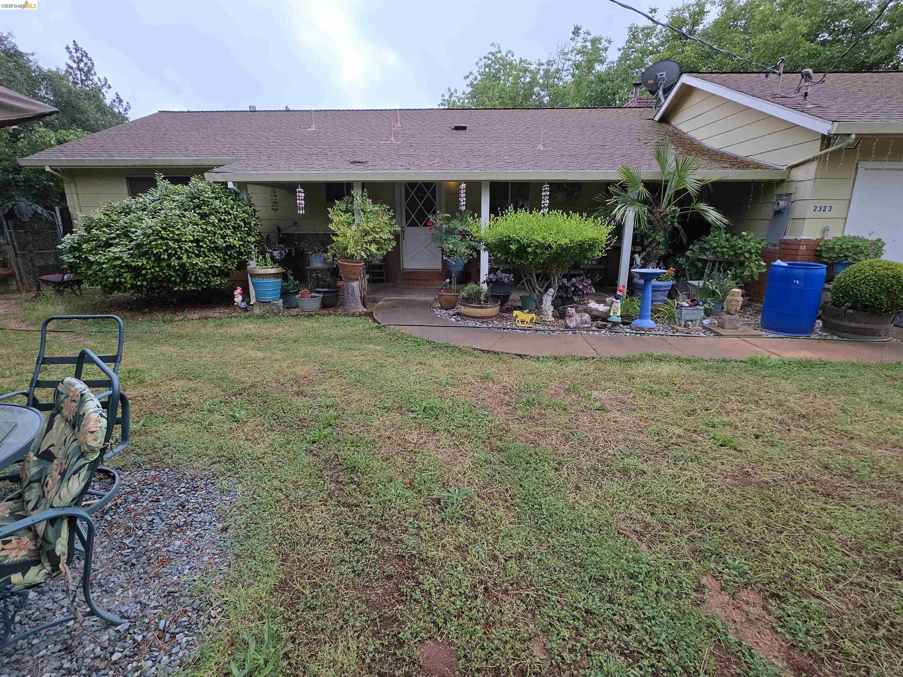 2323 Spink Road West Point, CA 95255 - Photo 4 of 17 Ranch-style exterior with a covered porch, light yellow siding, and a paved walkway