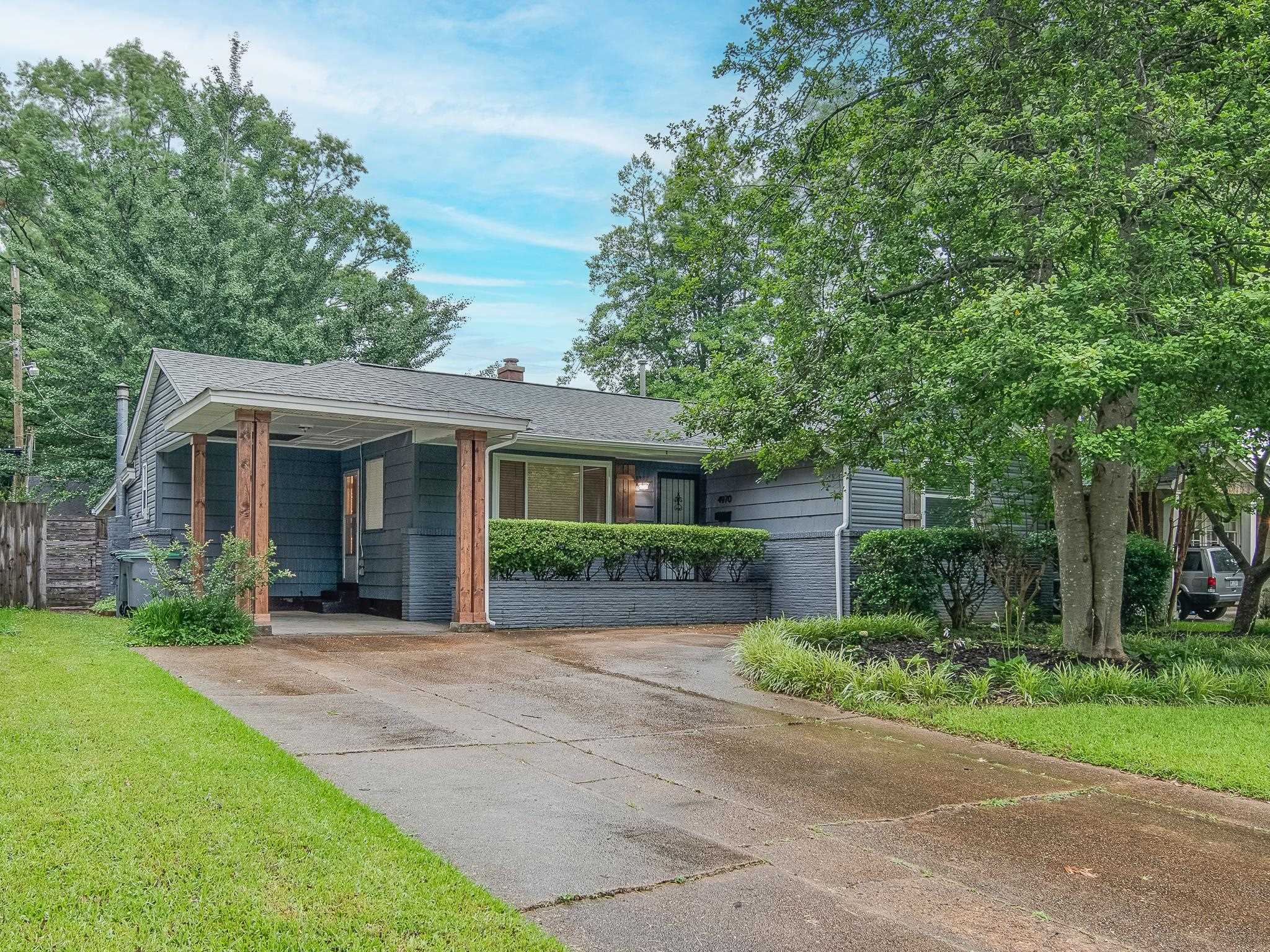 front view of a brick house with a yard