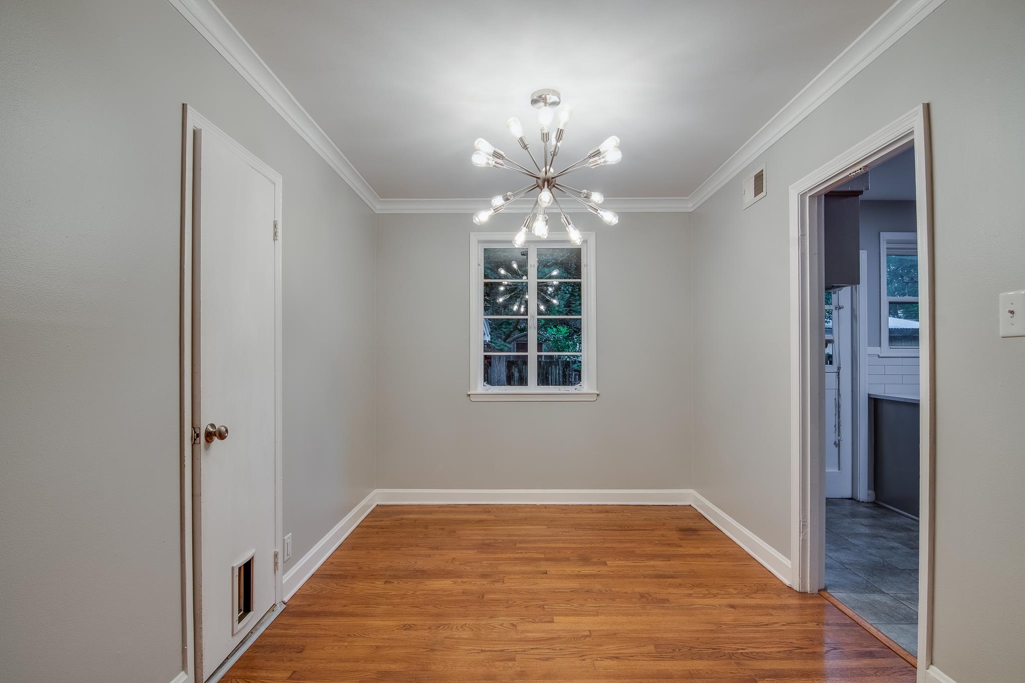 4970 Sequoia Road Memphis, TN 38117 - Photo 7 of 31 a view of a hallway with a chandelier fan and wooden floor