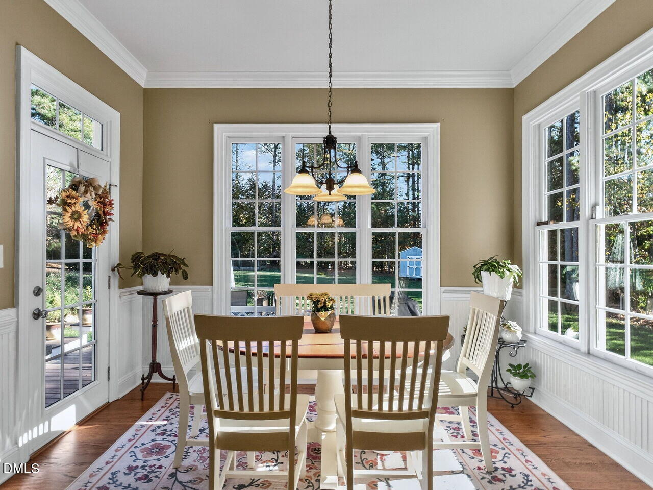 10312 Old Creedmoor Road Raleigh, NC 27613 - Photo 11 of 40 a dining room with furniture a chandelier and wooden floor