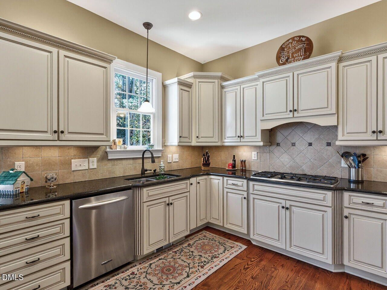 10312 Old Creedmoor Road Raleigh, NC 27613 - Photo 12 of 40 a kitchen with stainless steel appliances granite countertop a sink and cabinets with wooden floor