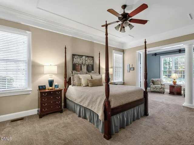 a bedroom with a bed a chandelier and a couch