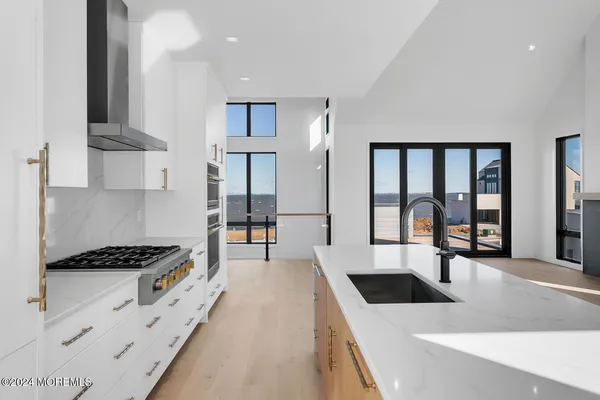 a kitchen with stainless steel appliances granite countertop a stove a sink and white cabinets