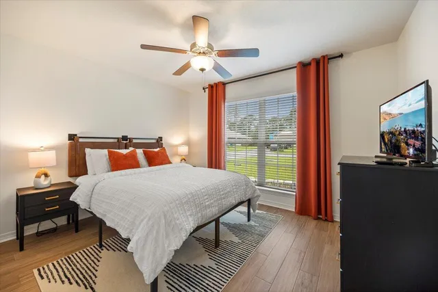 a bedroom with a bed and wooden floor