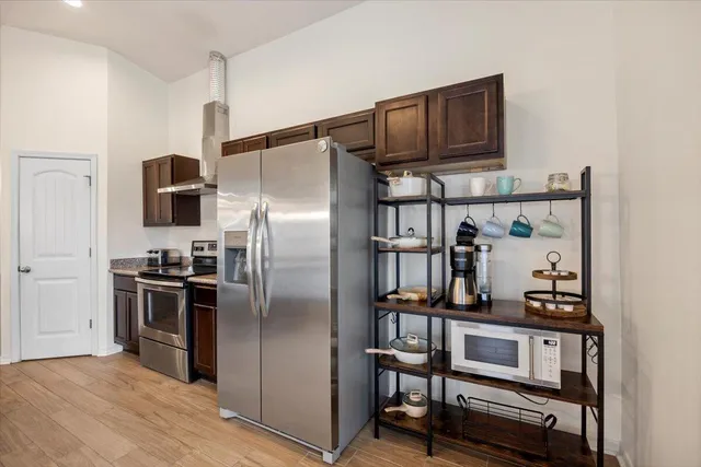 a kitchen with stainless steel appliances a refrigerator and a stove top oven